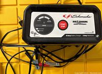 Front view of Schumacher battery charger and maintainer with control panel and visible cables.