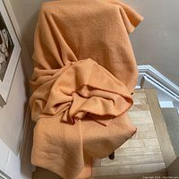 The wool blanket draped over a chair to show overall color and texture.