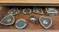 Eight-piece set of Wedgwood green jasperware with white classical relief decorations displayed in a drawer