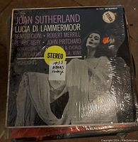 Close-up image of the Joan Sutherland Lucia Di Lammermoor album cover in plastic sleeve with stereo sticker and yellow pricing sticker.