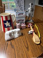 Image showing the full collection of Americana themed tabletop and kitchen items on a wooden table, including the pitcher, statuettes, shakers, wooden tongs and spoon.