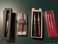 Overview of four collectible pens in their original boxes and display cases.