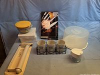 Overview of bowls with lids, cutting tool set, cake holder, spice jars, and sugar bowl