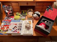 Full view of the collection showing Ryobi screwdriver kit, race car display, holiday figurines, photo frame kit, and plush panda on wooden desk.