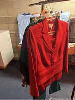 Red blazer-style jacket and other skirts or pants on hangers