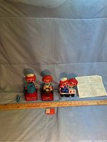 Photo of three Raggedy Ann and Andy figurines including battery-operated pencil sharpener, calendar with blocks showing date, and stapler with extra staples along with instruction sheet.