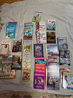 Overview photo showing the full assortment of young adult books spread out on a beige fabric background.