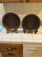 Two Heath Pottery dinner plates on stands, showing the front glaze finish and overall size.