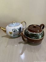 Side view of both tea pots showing floral design and color details