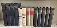Four volumes of History of the World War by Frank H. Simonds with dark blue cloth covers and spines, plus white and beige volumes of Harry S. Truman memoirs, two red and beige hardcover Charles Dickens books, and six black volumes of History of Our American People by Wilbur F. Gordy.