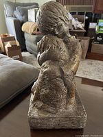 Full view of statue showing boy hugging dog statue, highlighting texture and general shape