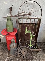 All items grouped including red tractor seat, green milk can, rusty plow wheel, feed trough, and potato planter tool