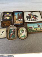 Overview of the lot showing all items laid out on a linen cloth surface. Includes framed paintings and baskets with bird motifs.