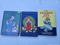 Three vintage Raggedy Ann and Raggedy Andy books with visible cover illustrations and titles, showing good condition overall.