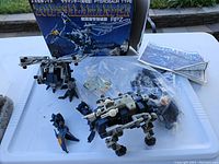 Full lot display showing Zoids Salamander Plus model, box, instruction manual, decal sheet, and extra parts in plastic bag.