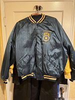 Front view of black satin Teamsters jacket with embroidered logo on chest and striped collar, cuffs, and waistband.