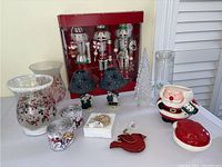 Photo shows entire collection of Christmas decorations including three 15" nutcrackers in original box, assorted vases, candle holders, ribbons, ornament, and cookie jar.