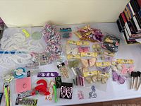 Overview of all crafting materials including butterfly clips, stencils, stickers, balloons, fringe, and various small crafting tools.