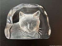 Clear glass cat paperweight featuring detailed cat face and whiskers, measuring about 3.5 inches tall and 4.5 inches wide.