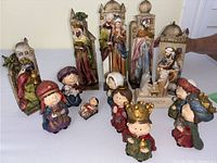 Two children's nativity sets figurines in cartoon and rustic styles