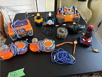 Wide view of all included gaming toys and joysticks arranged on a black surface showing overall lot contents