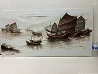 Full view of the large oil painting showing multiple Asian sailing ships with large brown sails on water, placed next to a water bottle for scale.