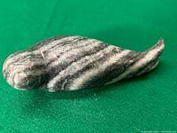 Top and side views of a hand carved natural stone seal figurine showing the patterned stone and smooth finish.