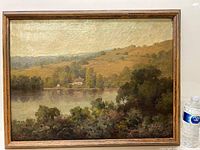 Full view of framed oil on canvas landscape painting showing a lake and hillside under diffused light