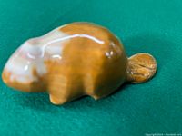 Top-down perspective showing the polished smooth body and natural marble coloration of the beaver figurine.