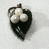 Front view of the vintage charm pendant showing carved jade leaf with three pearls and twisted gold filled stem.