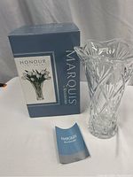Photo of Waterford Marquis collection flower vase with original blue box and folded booklet on a white surface, showing front view of vase and packaging