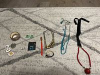 Wide shot of all costume jewellery items laid out showing necklaces, bracelets and various earrings.