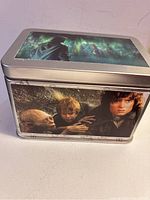 Front and side view of metal tin showing close up images of Frodo, Samwise, and Gollum from Lord of the Rings