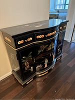 Curved front black cabinet with colorful floral and Asian landscape painted designs