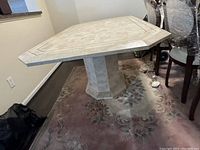 Corner view of the rectangular table top with octagonal cut corners and central pedestal base visible.