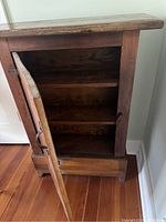 Interior view of cabinet showing two shelves and dark wood interior.