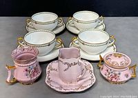 Overview of all items in set including four double handed cups with saucers, creamer and sugar bowl