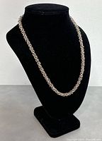 Necklace displayed on velvet bust showing full length and design of chain.