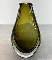 Front view of olive green hand blown glass vase showing teardrop shape and clear thick glass base.