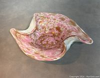 Pink and aventurine spotted Murano art glass bowl with wavy organic shape, side view showing flowing edges.
