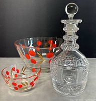 Photo showing cut glass decanter with stopper, large bowl and small bowl with red polka dots and gold leaf designs