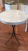 Photo of the round marble tabletop with visible natural pattern and metal edging.