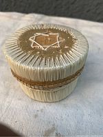 Three photos of a First Nation birch bark trinket box decorated with porcupine quillwork, showing the top star design, side view of the weaving, and the overall condition including surface wear and peeling.