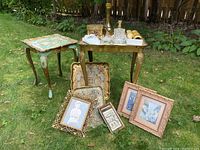 Lot arranged outdoors on grass with two Florentine tables, decorative tray, framed pictures, ring dishes, decanter, and napkin rings