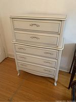 Full front view of white French Provincial dresser with four drawers