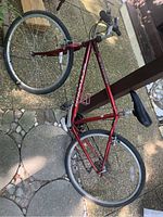 Full side view of red Schwinn mountain bike showing frame, wheels, saddle, and handlebars outdoors.