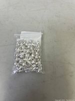 Small sterling silver stud earrings in a clear plastic resealable bag shown on a flat surface.