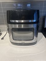 Front view of Bella Pro Series air fryer with glass window and stainless steel trim.
