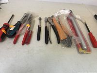 Overview of all hand tools laid out on a table, showing screwdrivers, socket wrenches, and wire cutters.