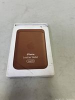 Front of original packaging box showing Apple iPhone Leather Wallet MagSafe with brown wallet image.